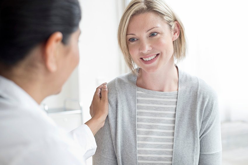 758310051 Female doctor with hand on patient's shoulder.